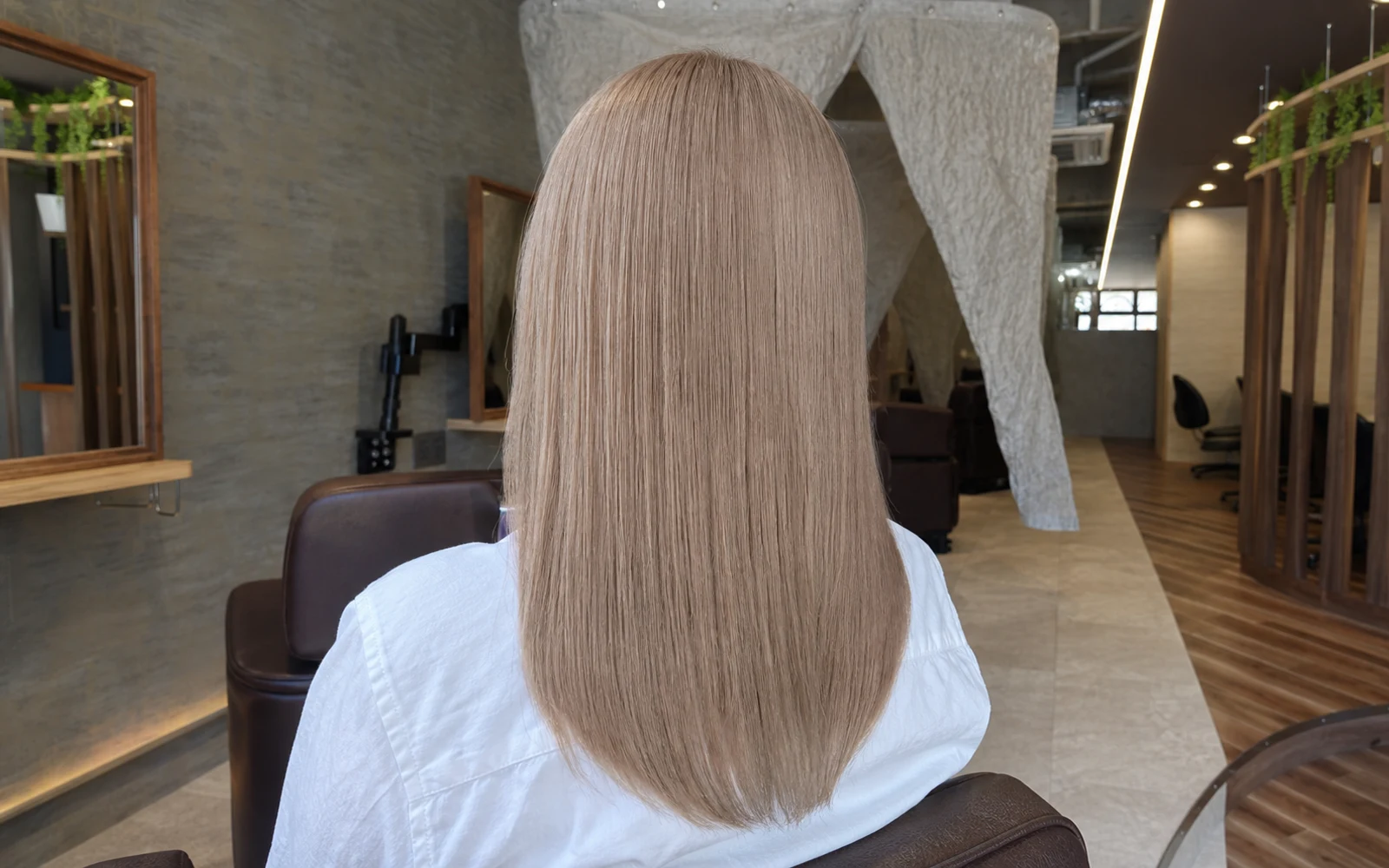 明るいベージュ系に仕上げたロングヘアの後ろ姿